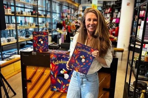 Nieuwland staat met het kinderboek Geluksvogel in haar hand